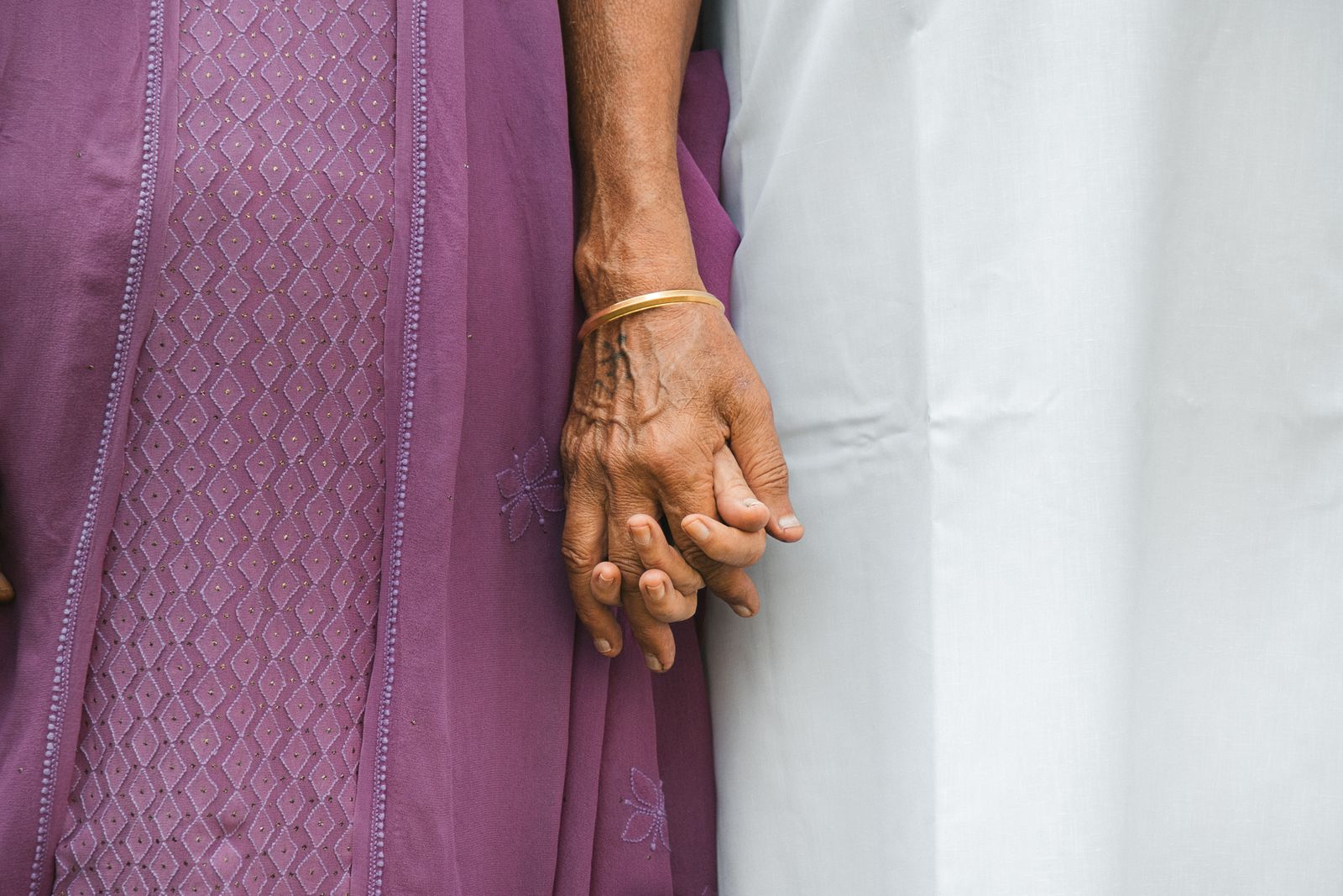 An elderly woman’s hand held by a younger family member